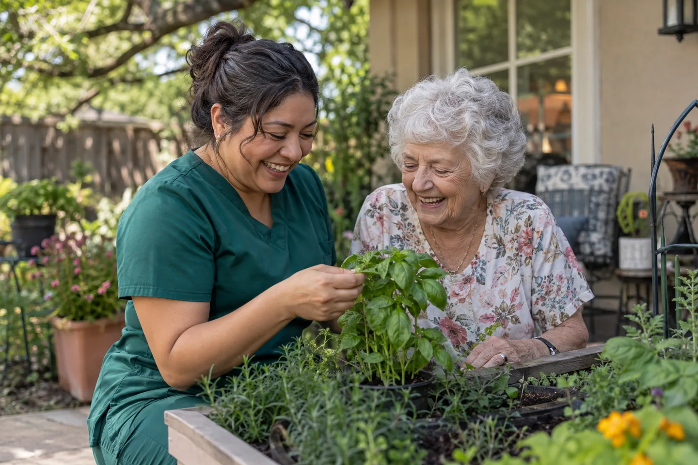 Illustrative scene: A female caregiver in green scrubs and an older woman laugh together while tending herbs in a garden